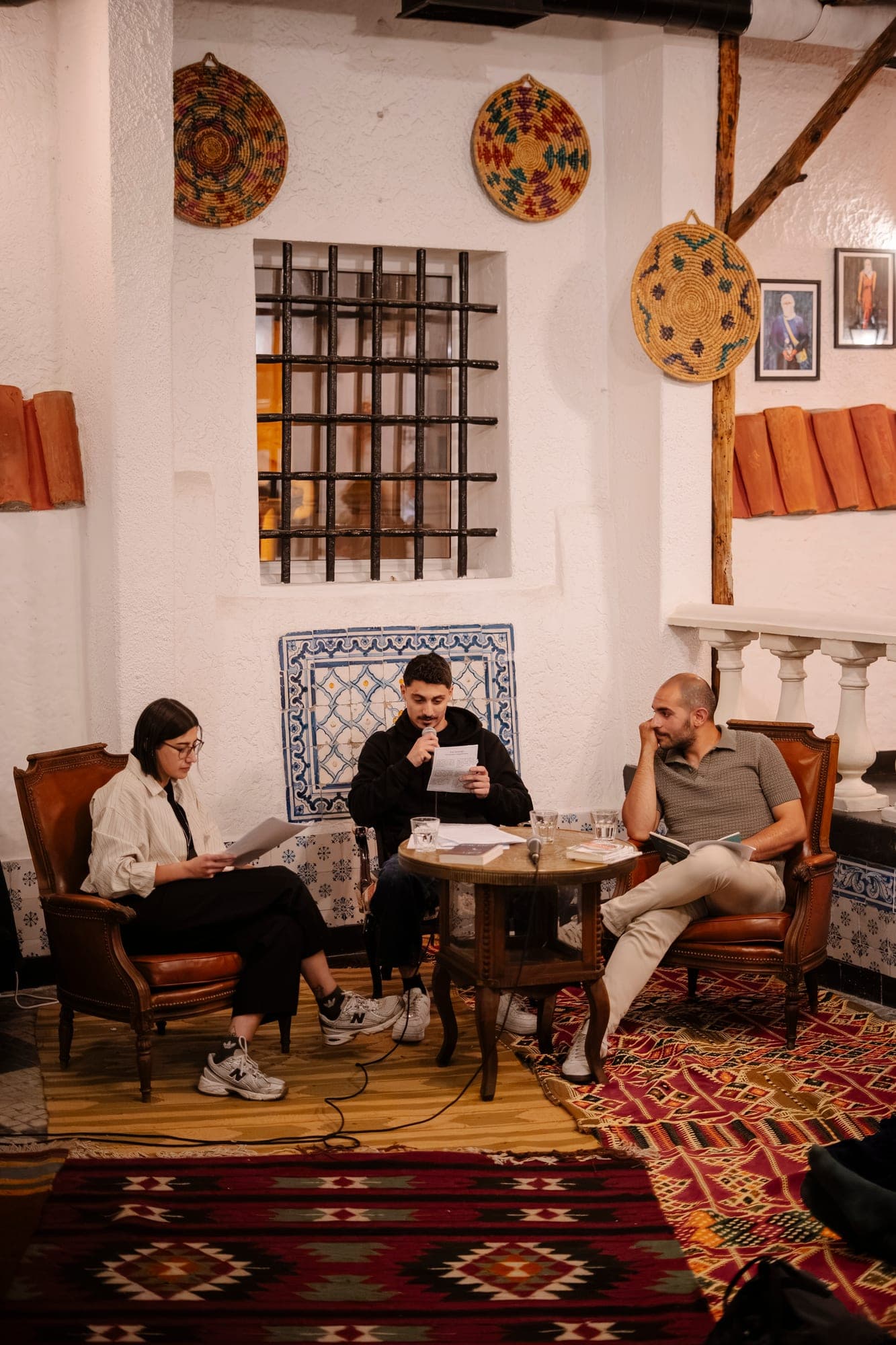 Three speakers in conversation at a book talk.