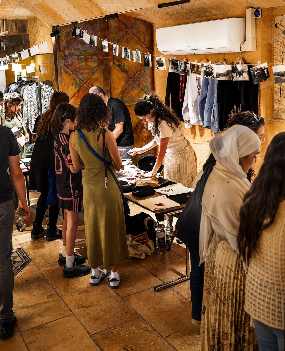 Visitors browsing clothing and crafts at a market day.